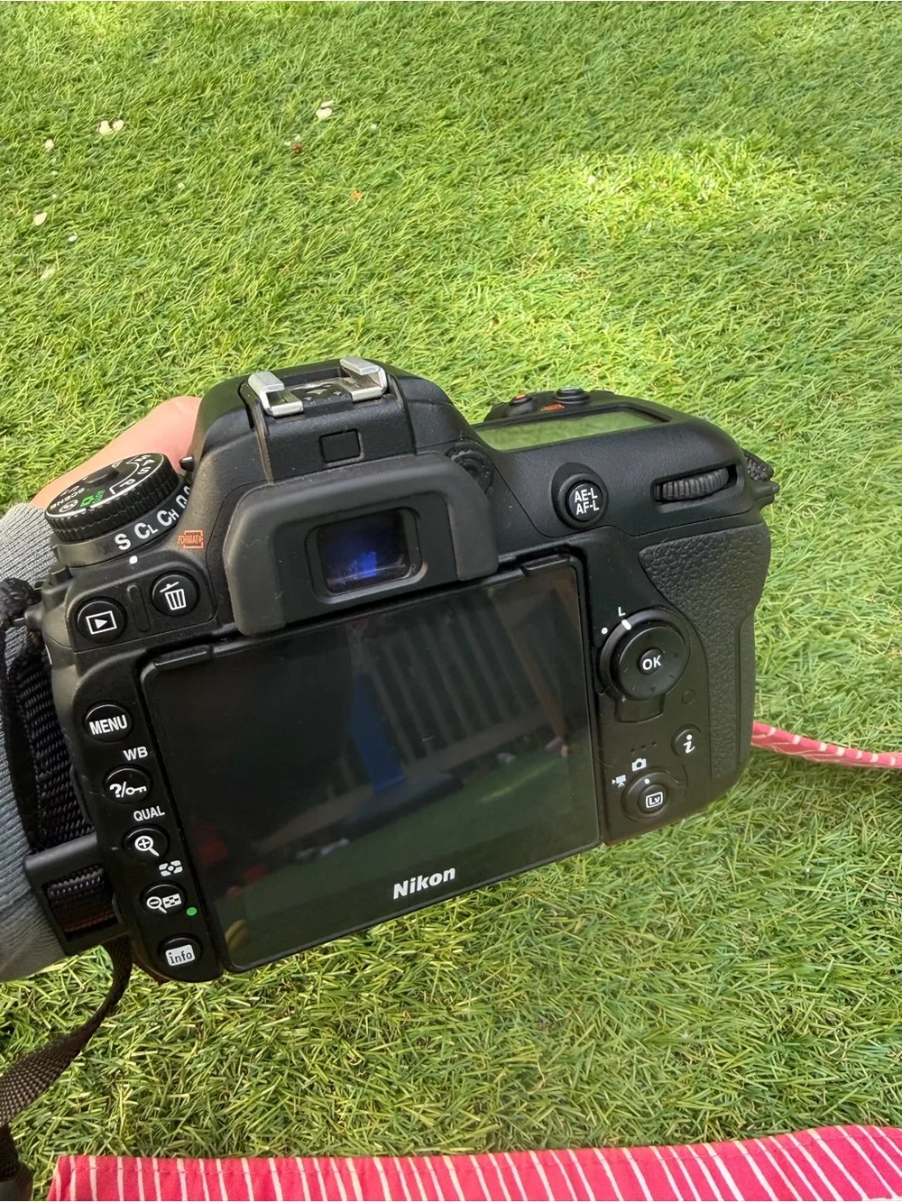 Nikon D7500 DSLR Camera with Black Lens and Red Strap